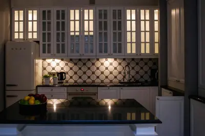 a kitchen with white cabinets and a bowl of fruit on a counter at Royal Residence by OTR in Kraków