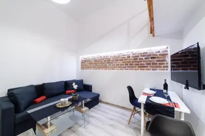 a living room with a blue couch and a table at 2 Nights Apartments - great location, right next to Main Rail and Bus Station, 10 min to Main Square by foot in Kraków