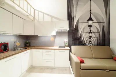 a kitchen with white cabinets and a couch at 2 Nights Apartments - great location, right next to Main Rail and Bus Station, 10 min to Main Square by foot in Kraków