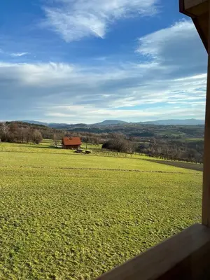 a view of a field with a barn in the distance at Fantastic View Vineyard Beskid Mountains in Gruszów