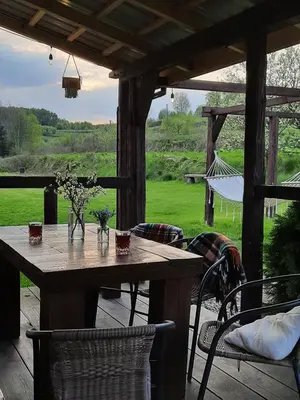 a wooden table and chairs on a patio with a view at Gospodarstwo Gościnne Księżycówka in Rajbrot