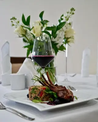 a plate of food and a glass of wine on a table at Hotel Dąbrowski in Oświęcim