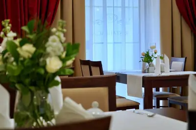 a dining room with tables and a vase of flowers at Hotel Dąbrowski in Oświęcim