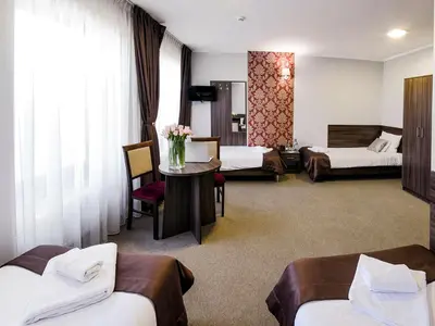 a hotel room with two beds and a table at Hotel Dąbrowski in Oświęcim