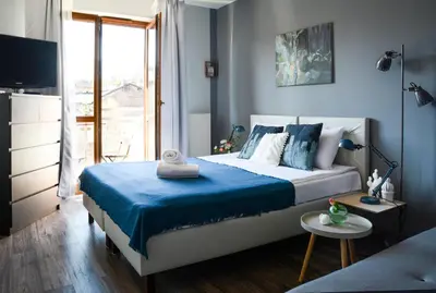a bedroom with a bed with blue sheets and a television at Vinyl Apartment Old Town in Kraków