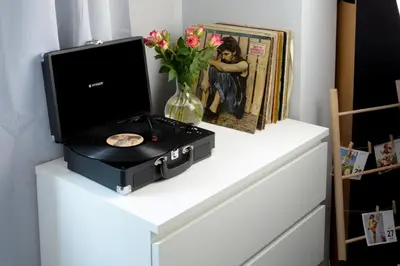 a white cabinet with a record player and a vase with flowers at Vinyl Apartment Old Town in Kraków