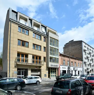 a large building with cars parked in a parking lot at Vinyl Apartment Old Town in Kraków