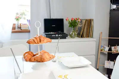 a table with two tiers of pastries and croissants at Vinyl Apartment Old Town in Kraków