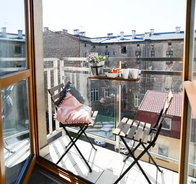 a balcony with two chairs and a table on a balcony at Vinyl Apartment Old Town in Kraków