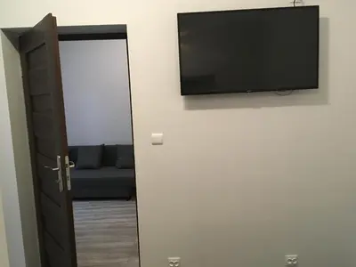 a flat screen tv on a wall next to a door at City Space Apartments in Kraków