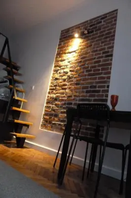 a chair in a room with a brick wall at City Space Apartments in Kraków