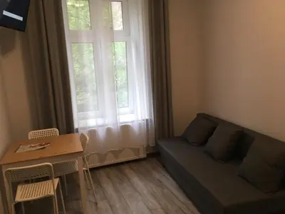 a living room with a couch and a table and a window at City Space Apartments in Kraków