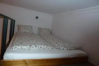 a white bed with a wooden frame and pillows at City Space Apartments in Kraków