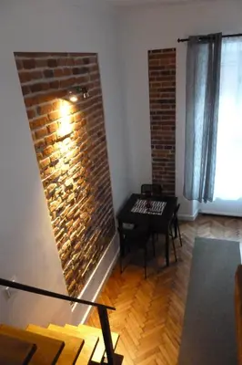 a living room with a brick wall and a table at City Space Apartments in Kraków