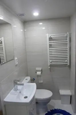 a white bathroom with a toilet and a sink at City Space Apartments in Kraków