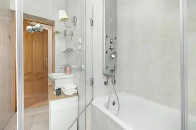 a bathroom with a bath tub and a sink at Sunshine apartment in Kraków