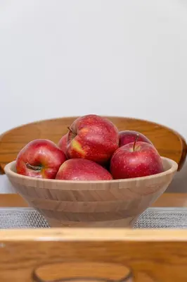 a wooden bowl of apples sitting on a table at Sunshine apartment in Kraków
