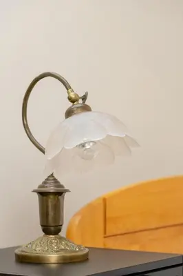 a lamp with a white flower on top of a table at Sunshine apartment in Kraków