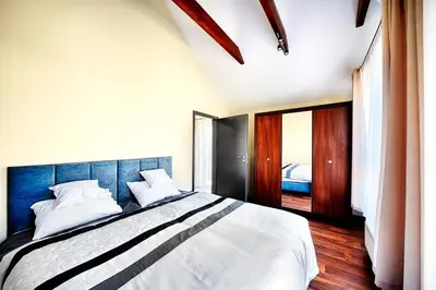 a bedroom with a large bed with a blue headboard at Apartamenty Salt Delux in Wieliczka