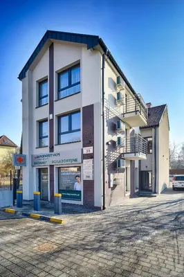 a large white building with stairs on the side of it at Apartamenty Salt Delux in Wieliczka