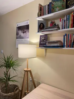 a room with a table and a lamp and books at Górskie Zacisze in Zawoja