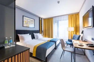 a hotel room with a bed and a desk at Grand Ascot Hotel in Kraków