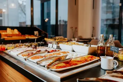 a buffet with several trays of food on a table at Grand Ascot Hotel in Kraków