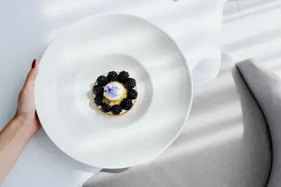 a person holding a plate with a dessert on it at Grand Ascot Hotel in Kraków