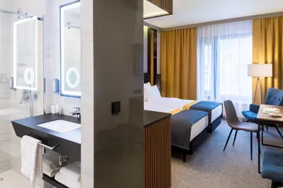 a hotel room with a bed and a bathroom at Grand Ascot Hotel in Kraków