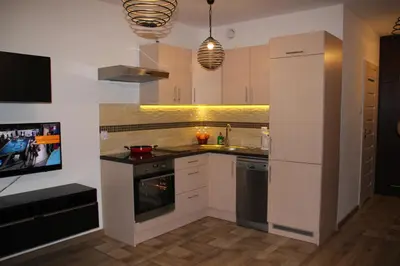 a kitchen with white cabinets and a stove top oven at Apartment Wielicka Cracow in Kraków