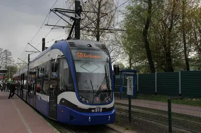 a blue and white tram is on the tracks at Apartment Wielicka Cracow in Kraków