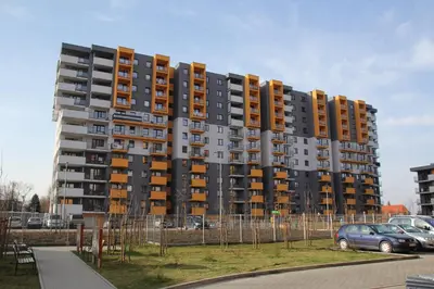 a tall apartment building in a parking lot at Apartment Wielicka Cracow in Kraków