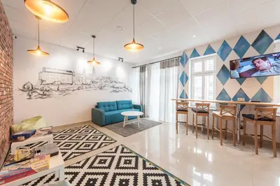 a living room with a blue couch and a table at Ginger ApartHostel in Kraków