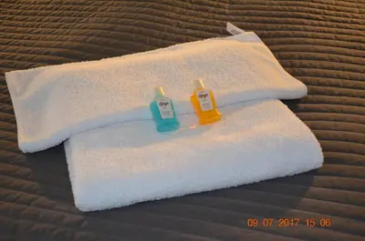two towels sitting on top of a bed at Ginger ApartHostel in Kraków