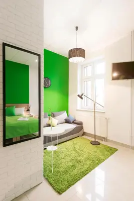 a living room with a couch and a green wall at Ginger ApartHostel in Kraków