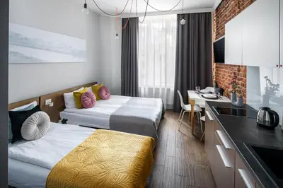 a hotel room with two beds and a kitchen at The Wavelo Collection in Kraków