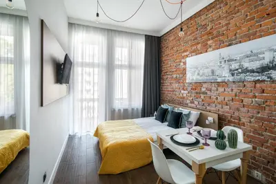 a bedroom with a bed and a brick wall at The Wavelo Collection in Kraków