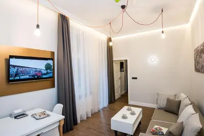 a living room with a couch and a tv on a wall at The Wavelo Collection in Kraków