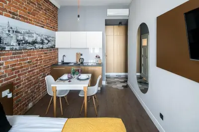 a dining room and kitchen with a brick wall at The Wavelo Collection in Kraków
