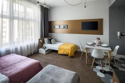 a hotel room with two beds and a table and a desk at The Wavelo Collection in Kraków