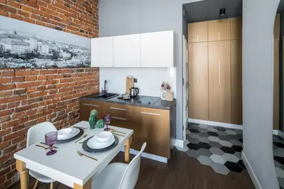 a kitchen with a white table and a brick wall at The Wavelo Collection in Kraków