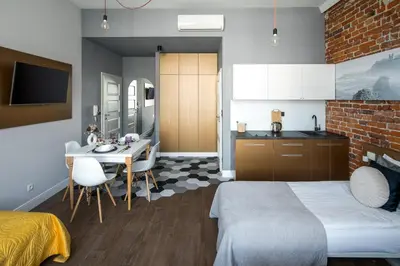 a bedroom with a bed and a table and a kitchen at The Wavelo Collection in Kraków