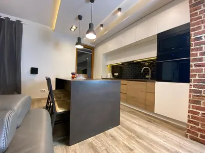a kitchen with a bar and a brick wall at P&J Apartments Lubicz in Kraków