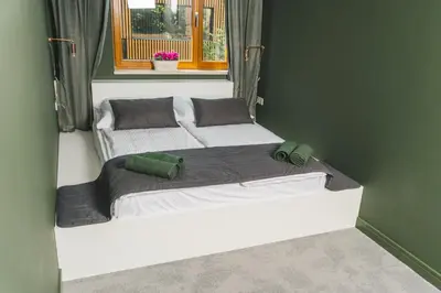 a bed in a room with a window at P&J Apartments Lubicz in Kraków