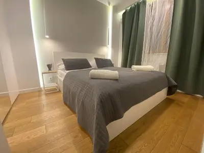a bedroom with a bed with two pillows on it at P&J Apartments Lubicz in Kraków