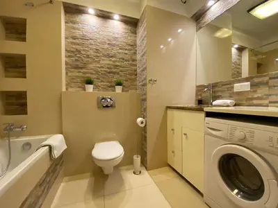 a bathroom with a toilet and a washing machine at P&J Apartments Lubicz in Kraków