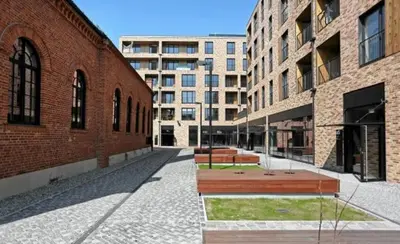 a street with two benches in front of buildings at P&J Apartments Lubicz in Kraków