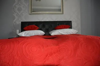 a red bed with four pillows and a red blanket at Angel City MARCO in Kraków