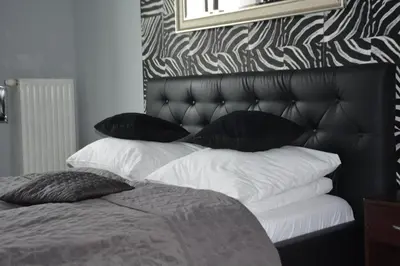 a bedroom with a bed with black and white pillows at Angel City MARCO in Kraków