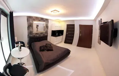 a bedroom with a bed and a table and a tv at Angel City MARCO in Kraków